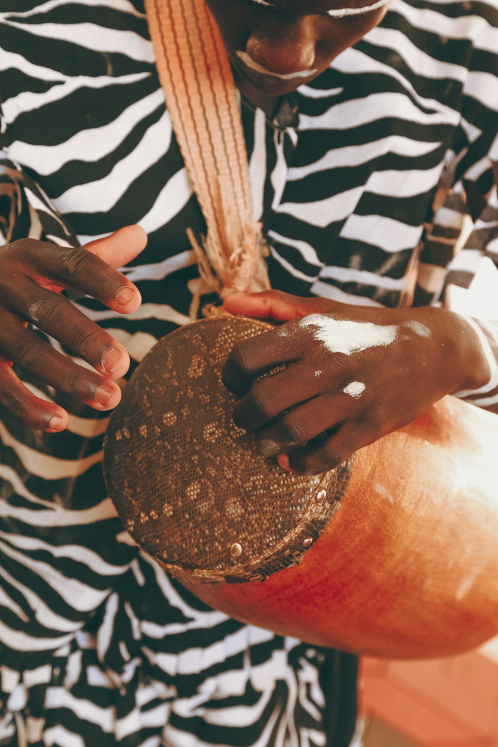 a woman in a zebra print shirt holding a drum