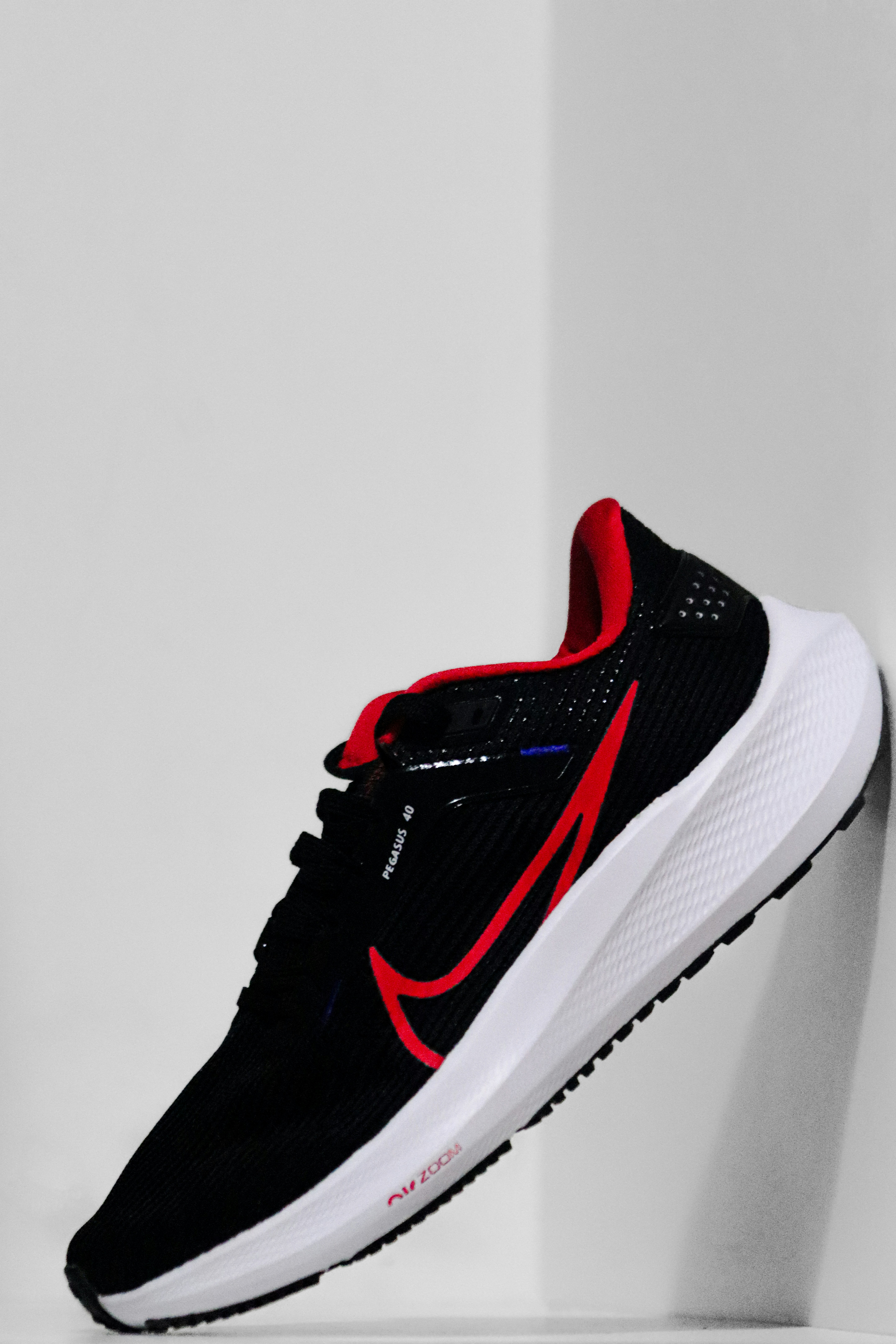 Nike Pegasus 41 athletic shoe on clean dark surface with dramatic lighting