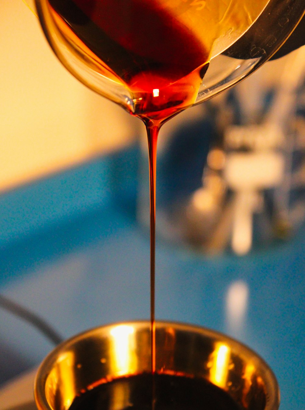 a glass of wine being poured into a bowl