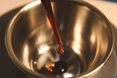 a spoon in a metal bowl filled with liquid