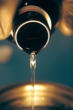 a close up of a wine glass being filled with wine