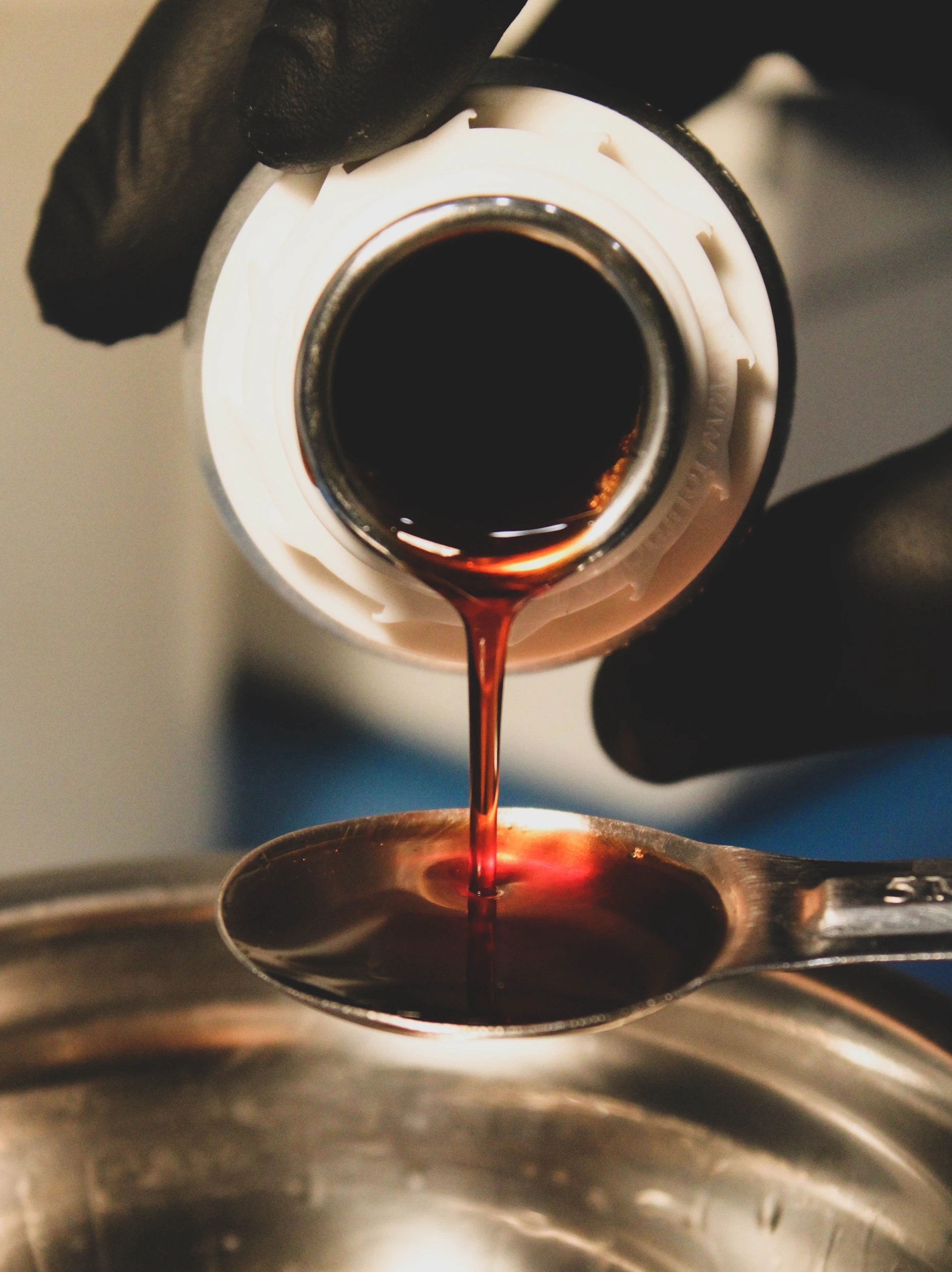 a person pouring sauce on a pan with a spoon