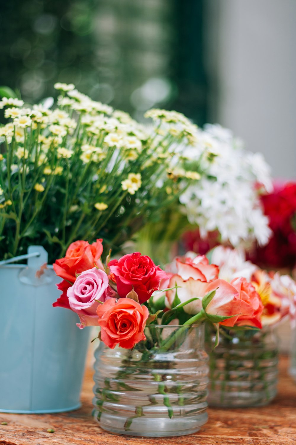 a group of vases filled with flowers on top of a wooden table