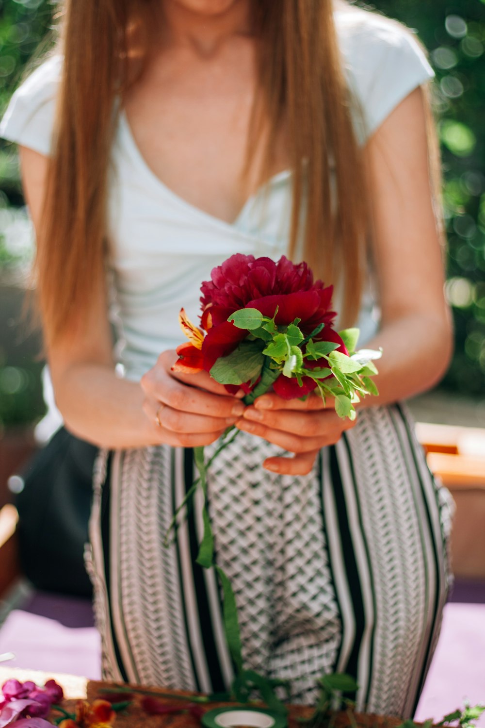 a woman holding a bouquet of flowers in her hands