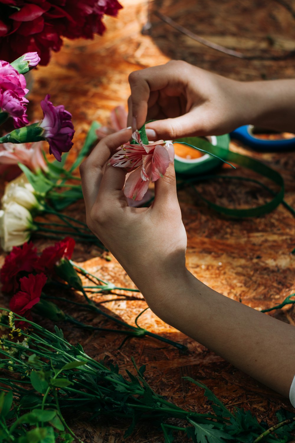 a person cutting flowers with scissors on a table