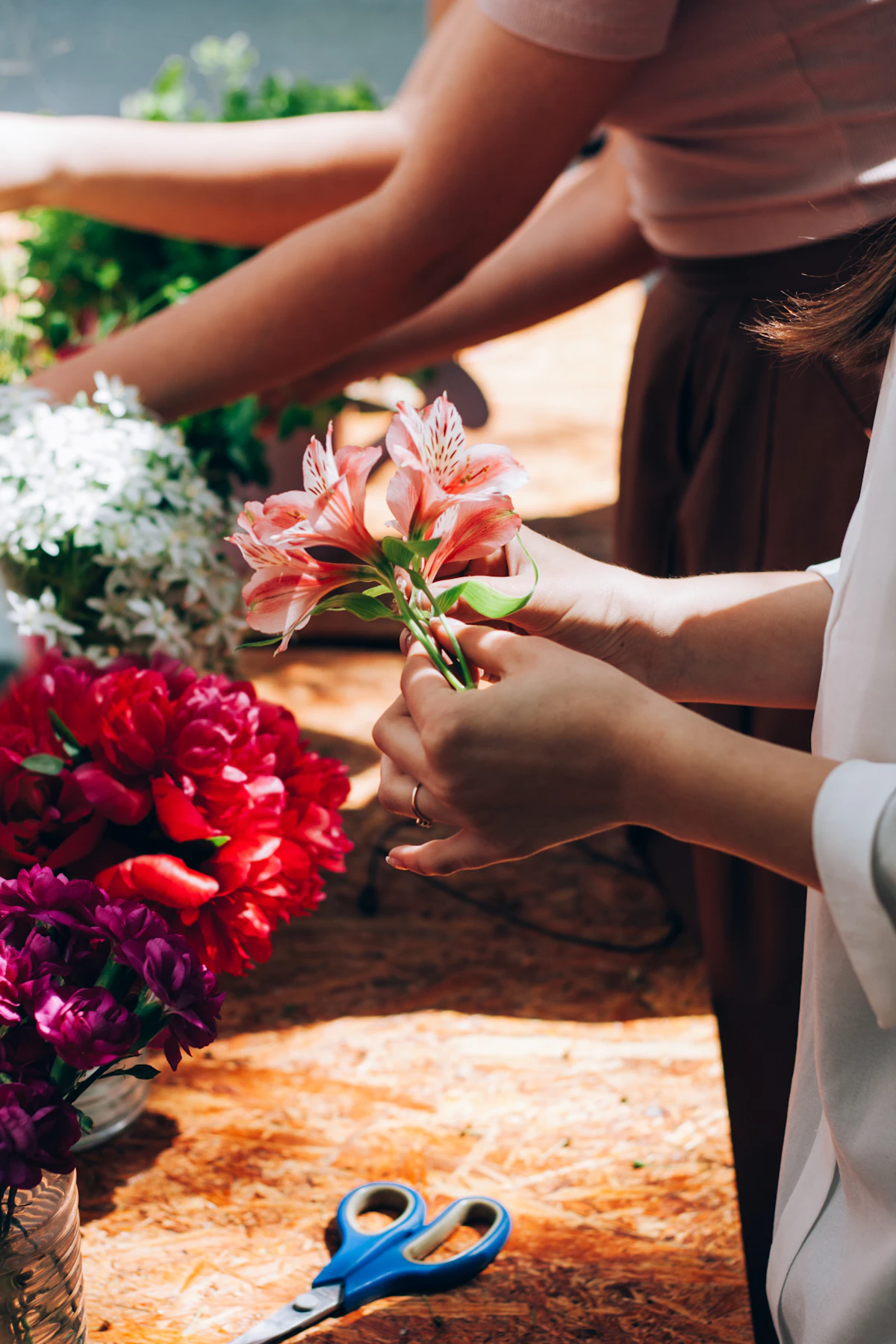 A florist cutting flower stems with scissors in the workroom