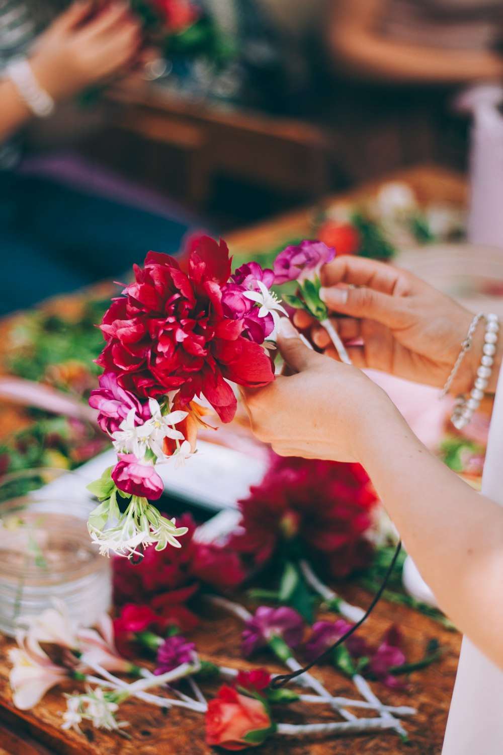 a close up of a person arranging flowers on a table