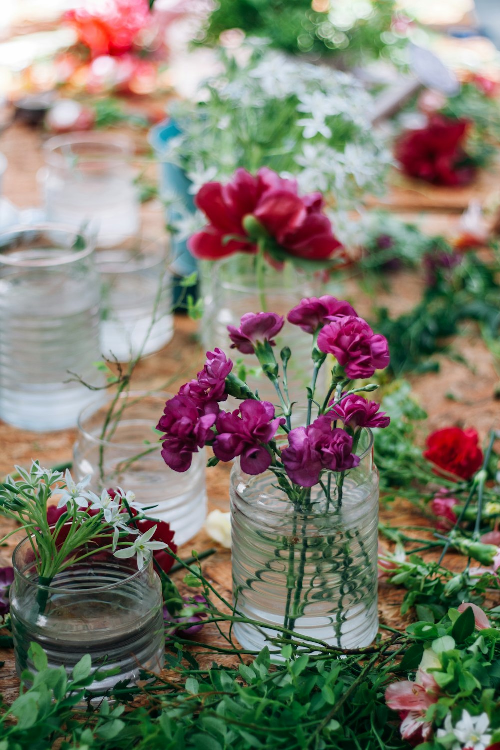 a table topped with lots of vases filled with flowers