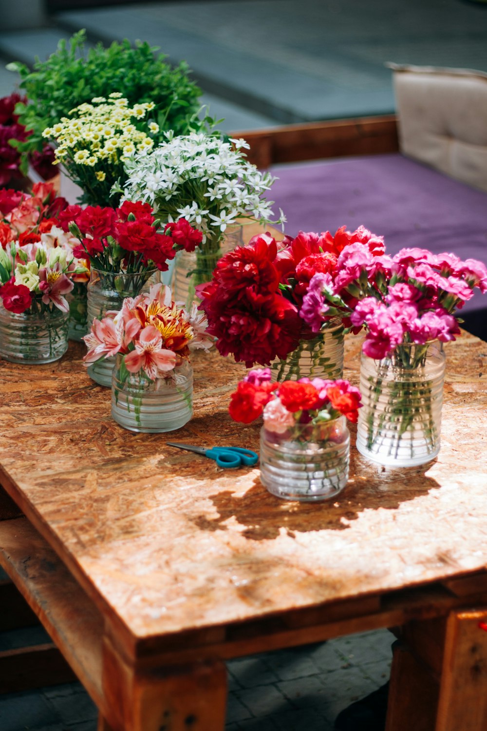 a wooden table topped with vases filled with flowers