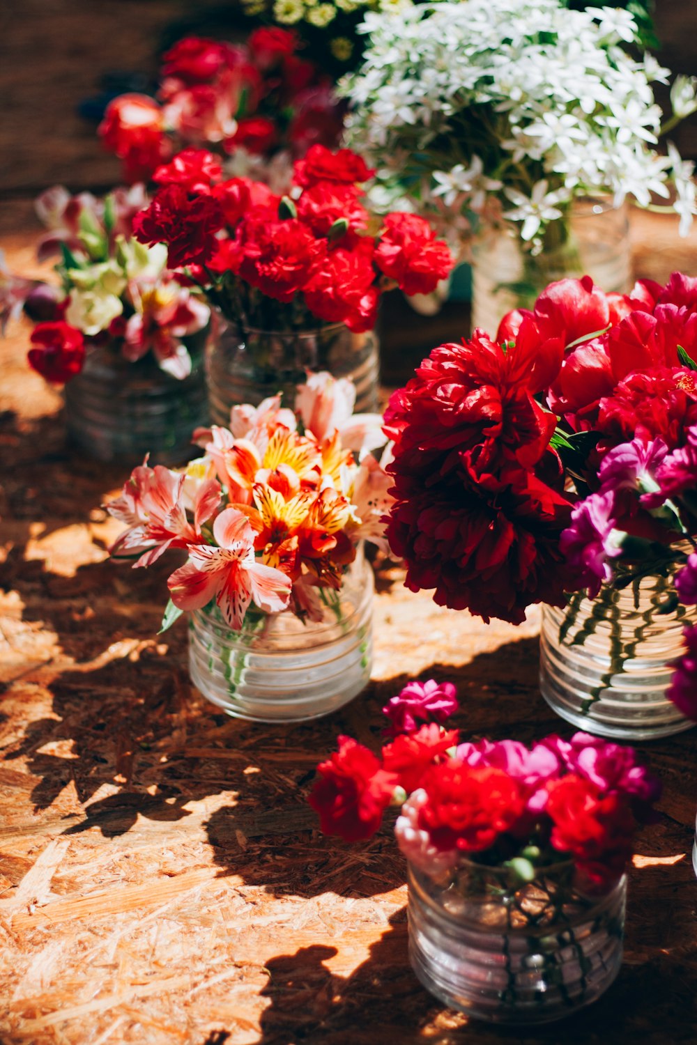 a group of vases filled with flowers sitting on a table