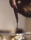 a drop of liquid is being poured into a glass bowl