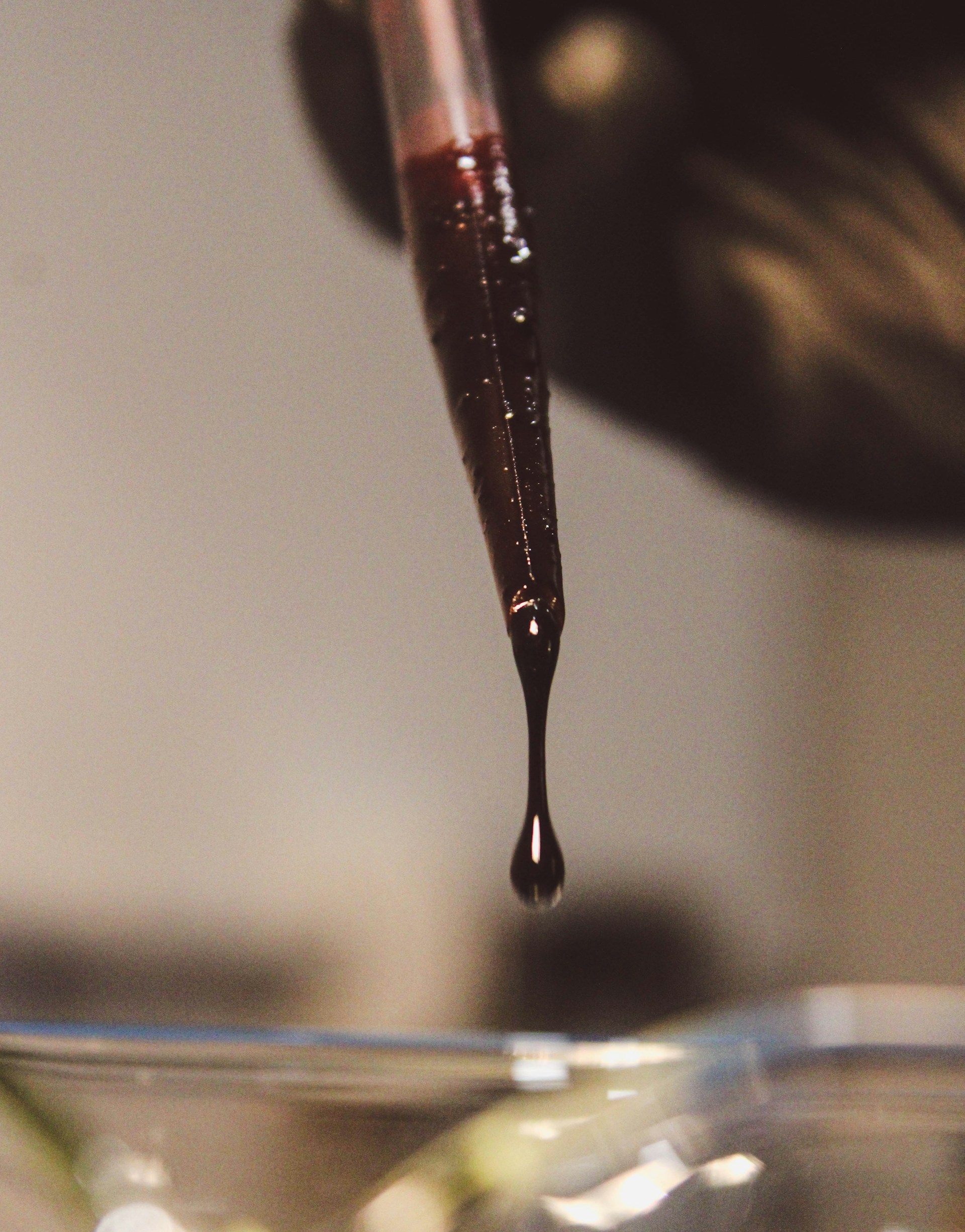 a drop of liquid is being poured into a glass bowl