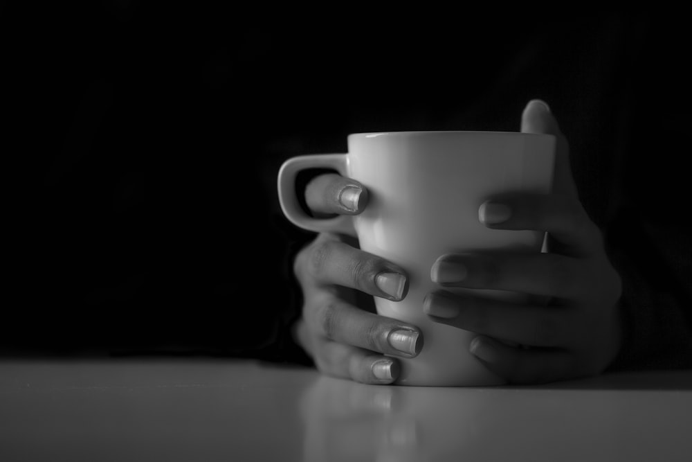 a woman's hands holding a coffee cup