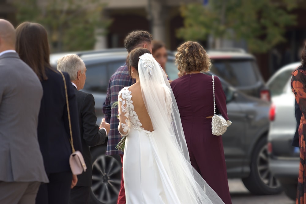 a bride and groom walking down the street