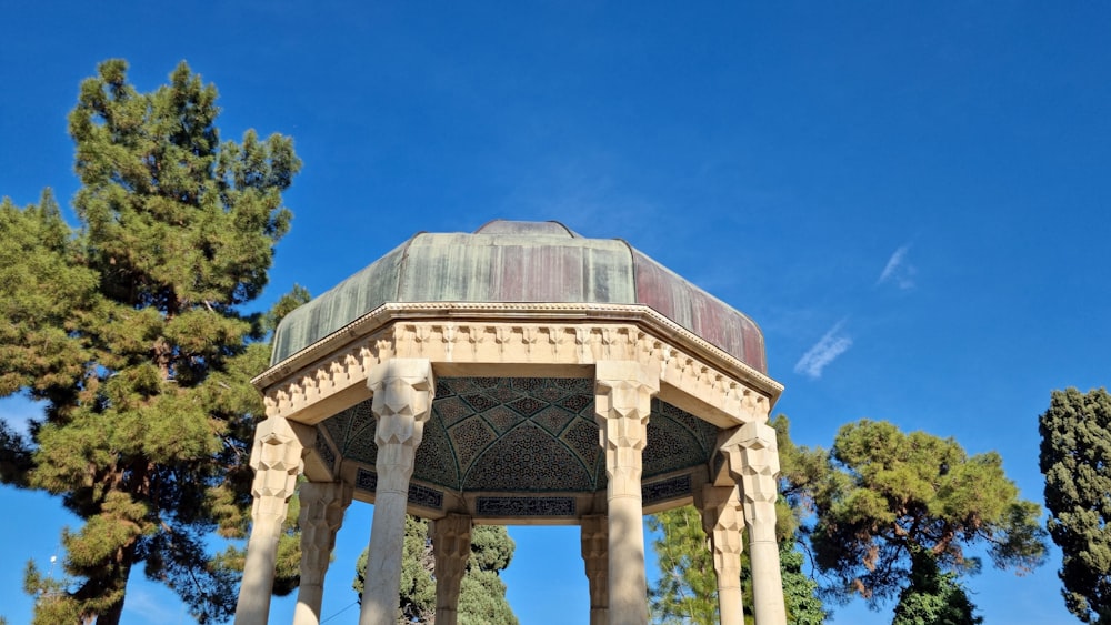 a gazebo in a park with trees in the background