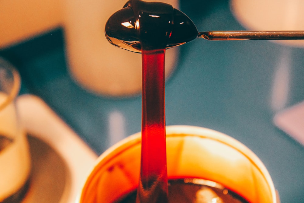 a spoon with liquid pouring out of it