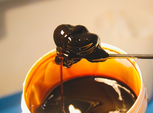 a spoon full of melted chocolate in a cup