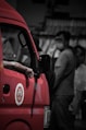 a red truck parked in front of a group of people