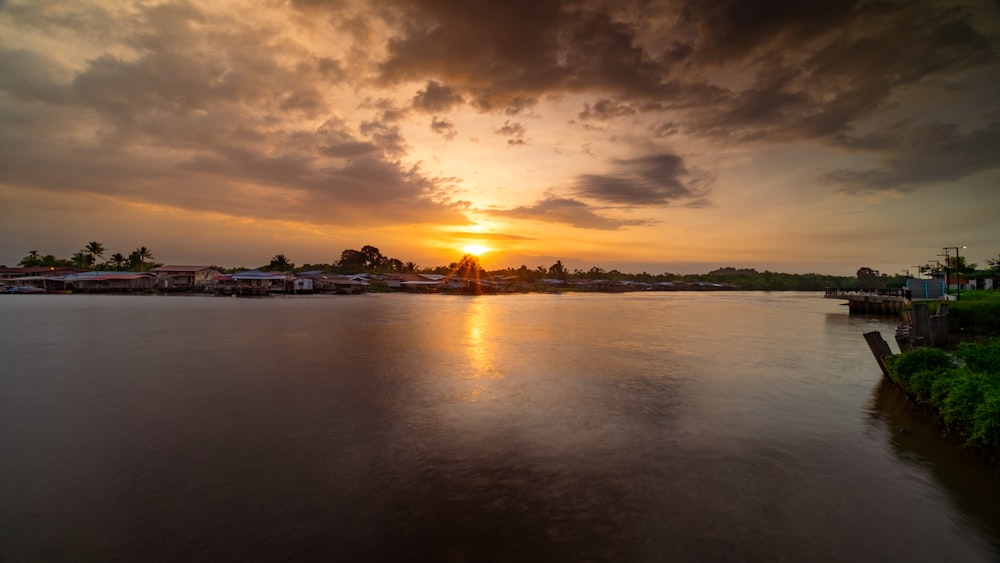 the sun is setting over a body of water