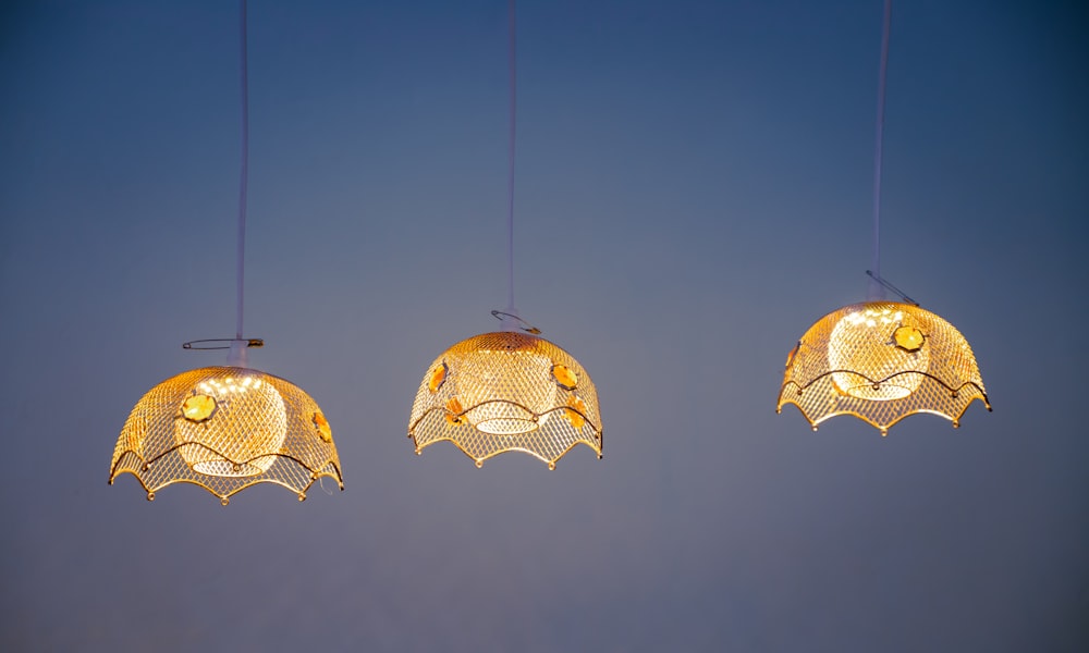 three lights hanging from a string in the sky