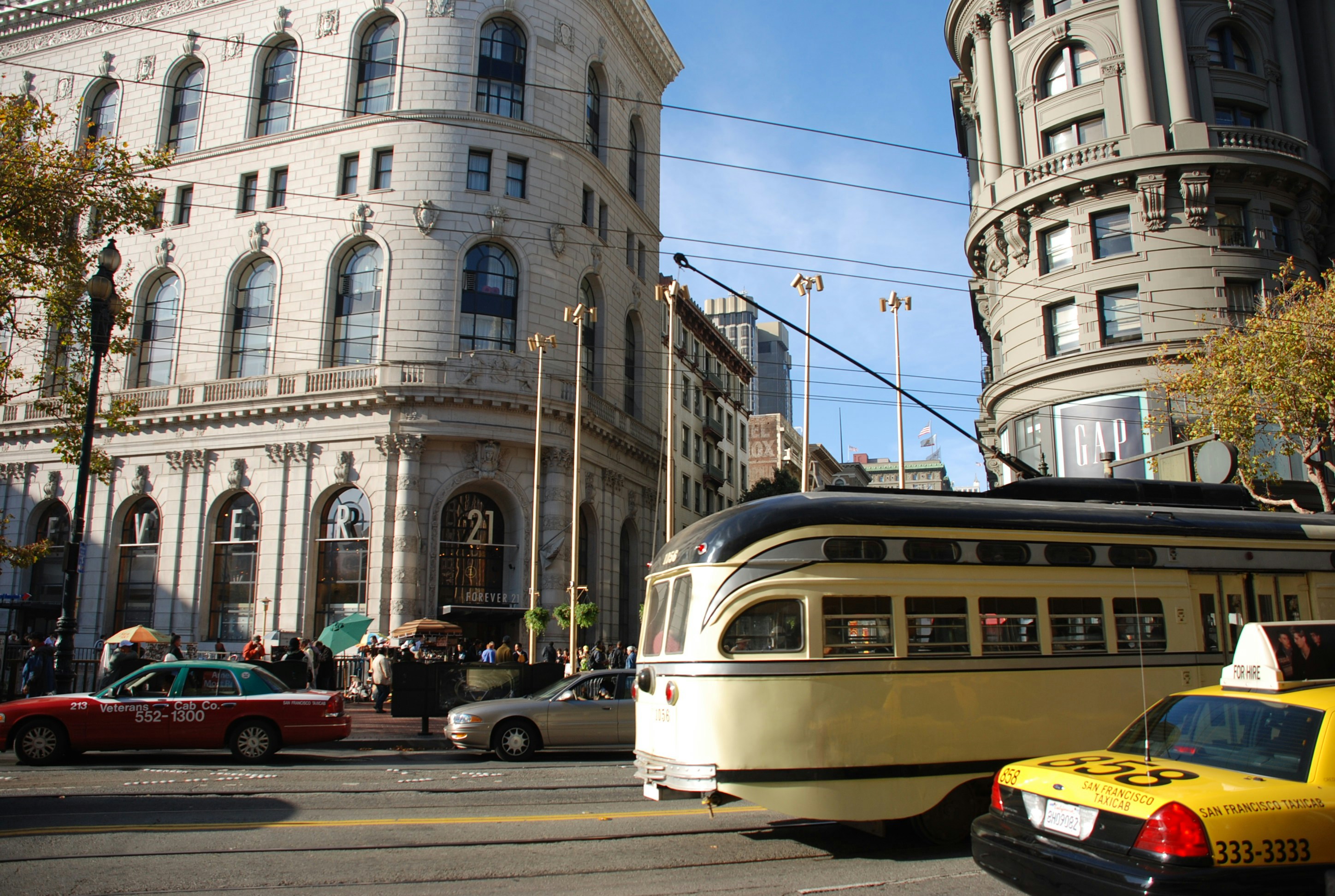 a street scene with cars and a trolley
