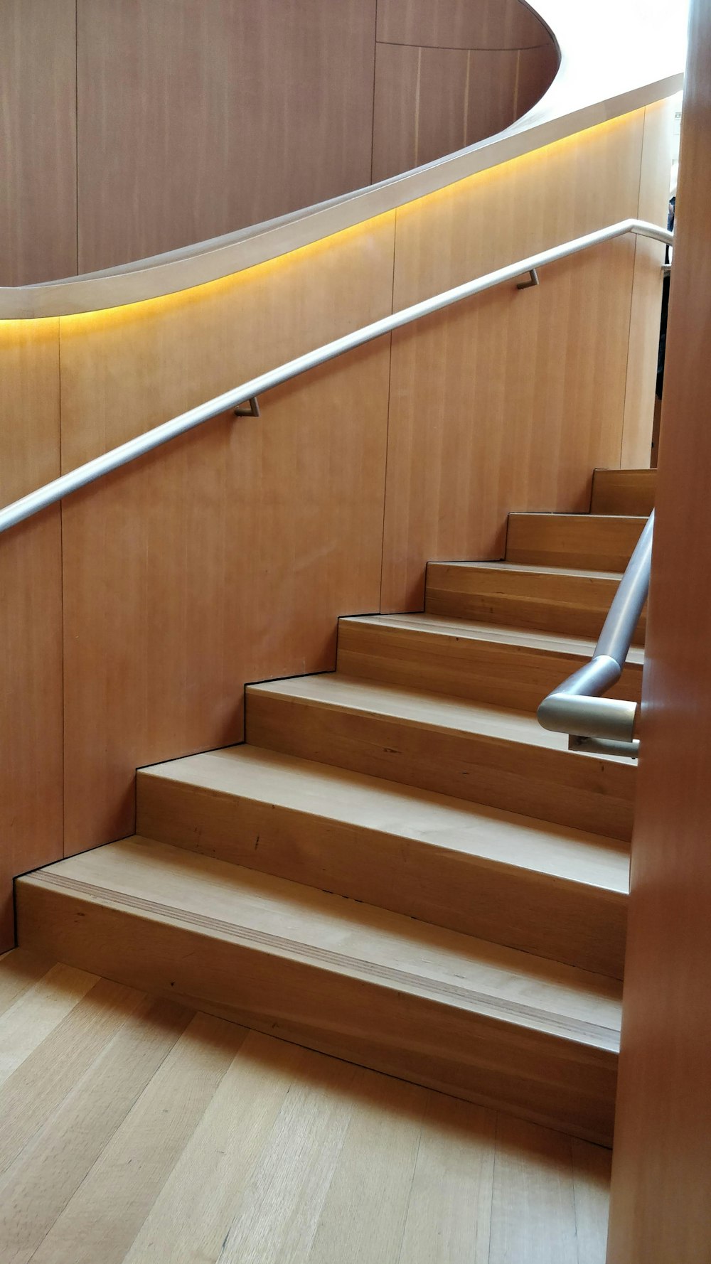 a set of wooden stairs with a metal handrail