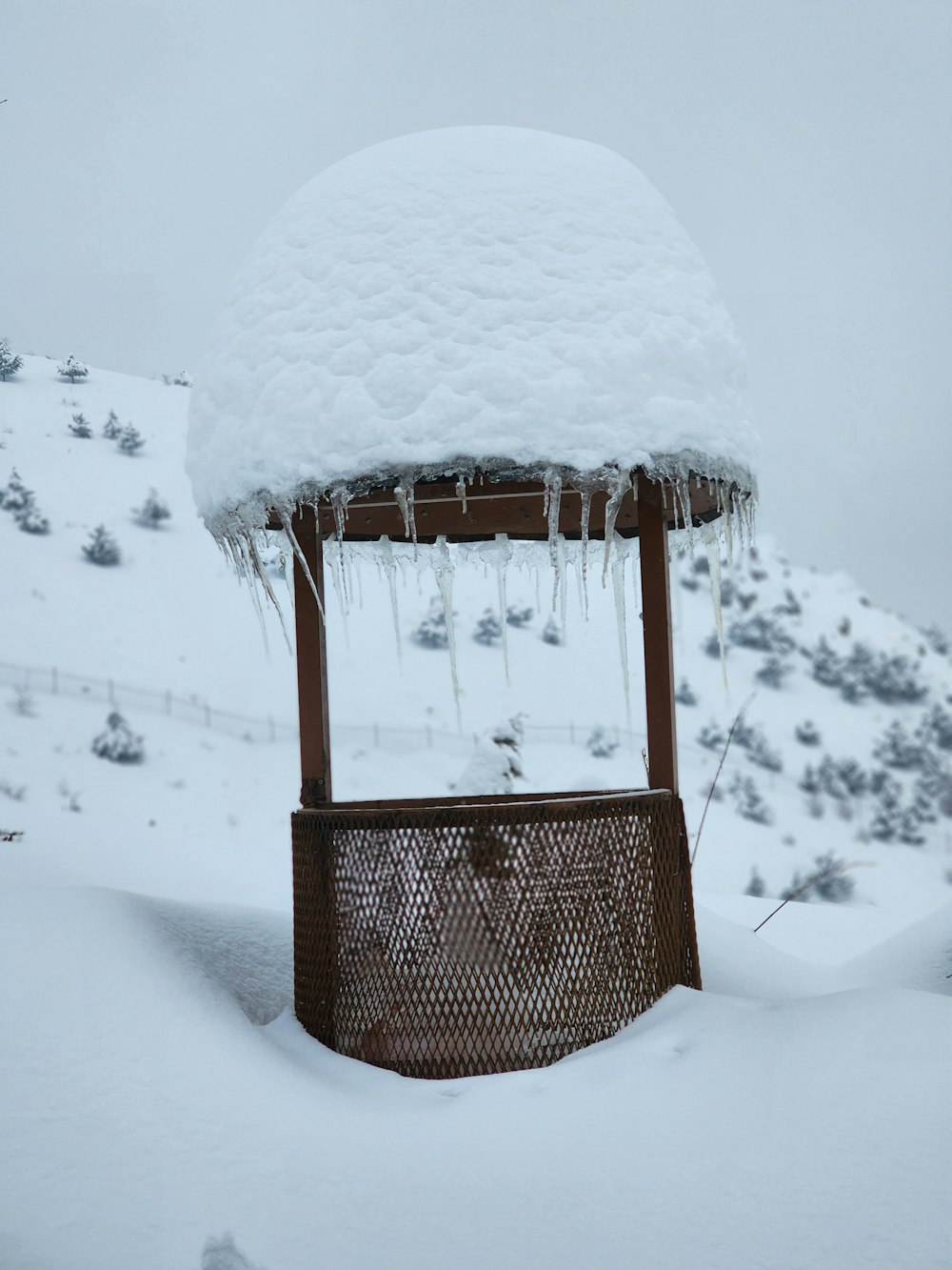 a gazebo covered in ice and snow on a mountain