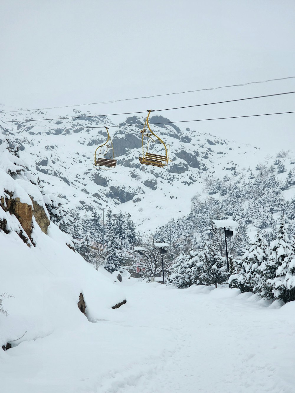 a ski lift going up a snowy mountain