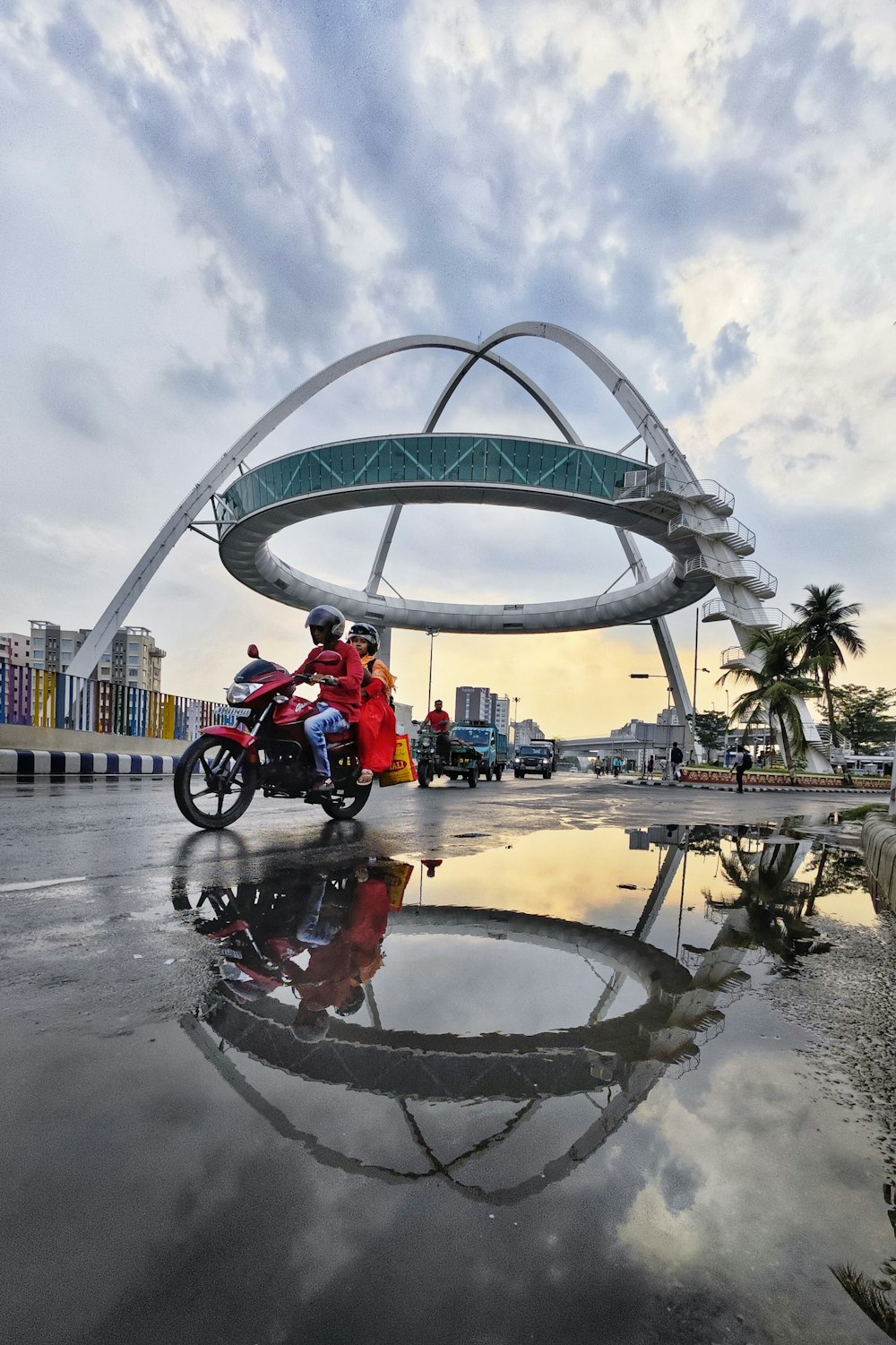 a man riding a motorcycle down a wet road