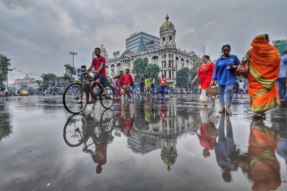 a group of people walking and riding bikes in the rain