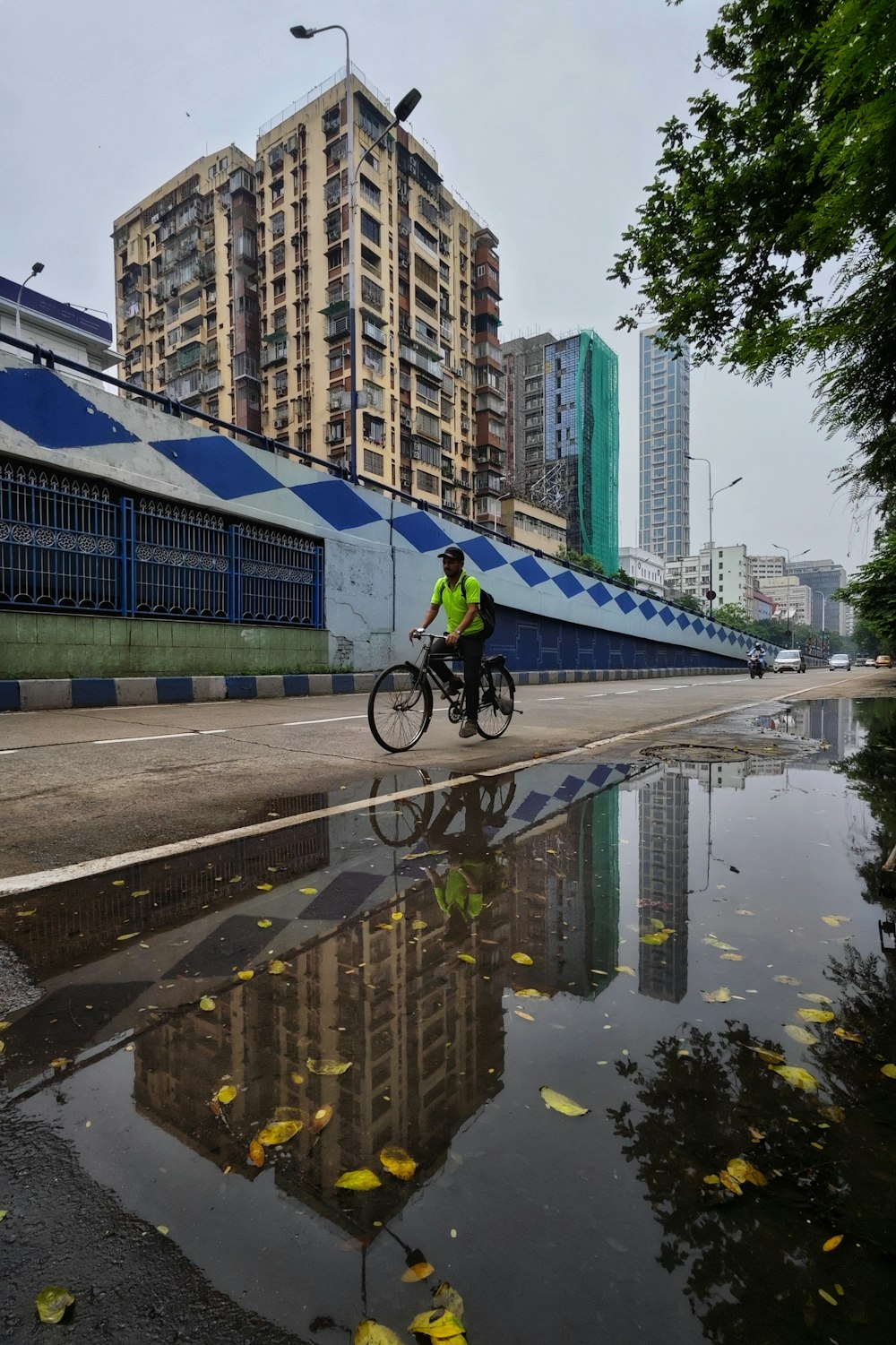 a man riding a bike down a street next to tall buildings