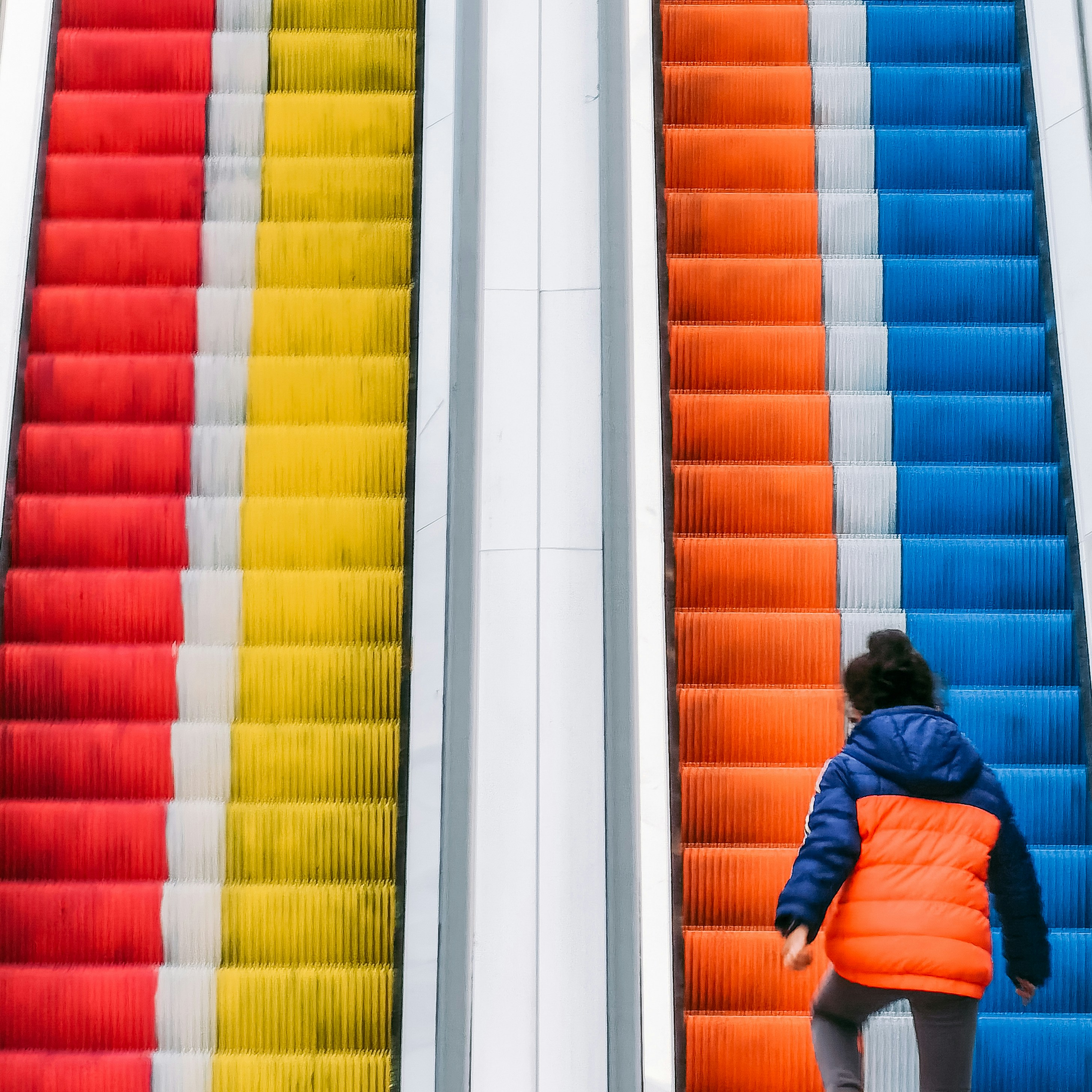 a woman walking up a set of colorful stairs