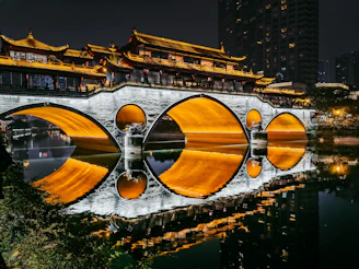 a bridge over a body of water with buildings in the background