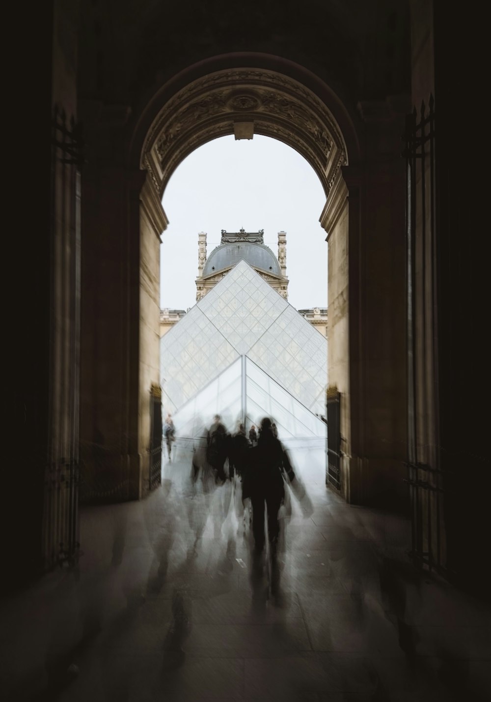 a group of people walking under an arch