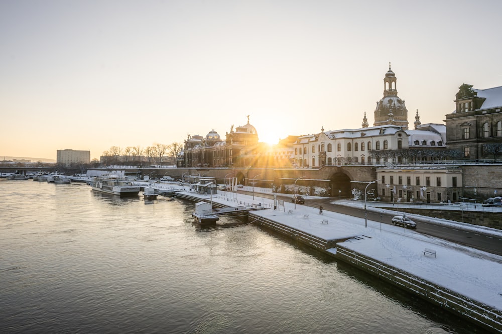 the sun is setting over a snowy river