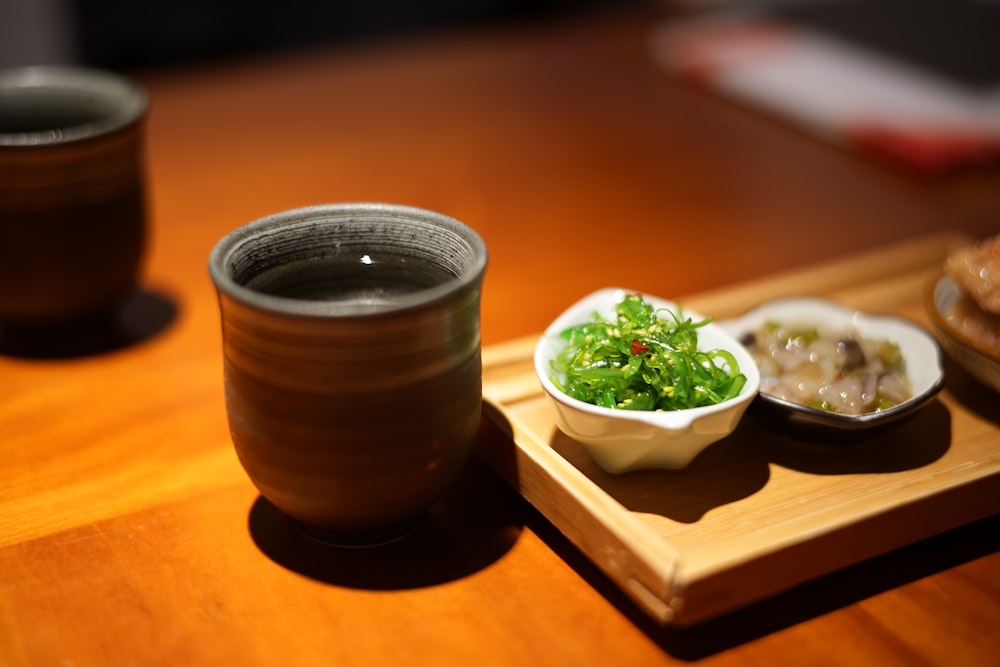 a wooden tray topped with a bowl of food