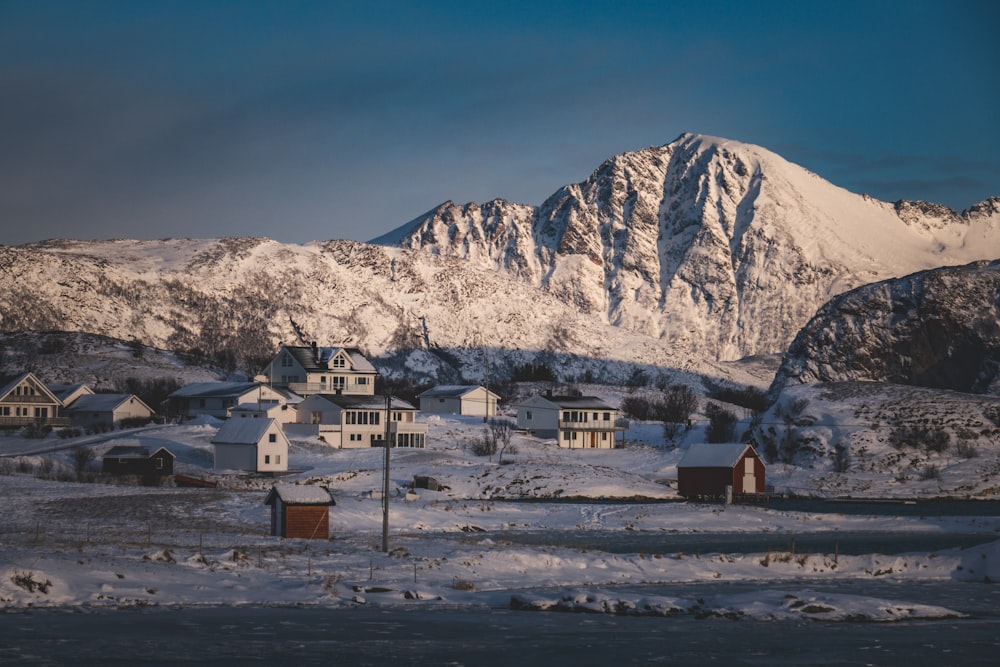 a snow covered mountain with houses in the foreground