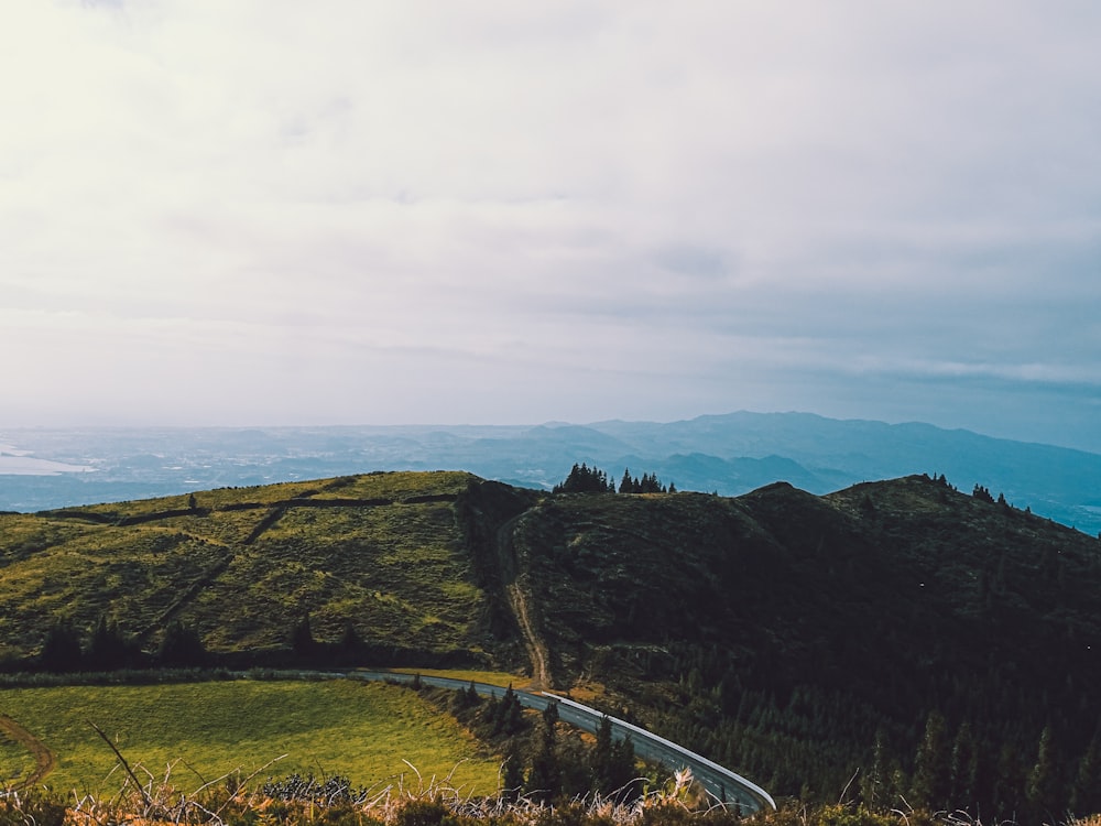 a scenic view of a winding road in the mountains