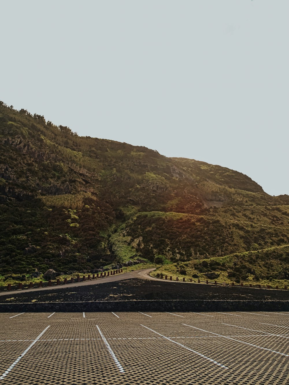 an empty parking lot in front of a mountain
