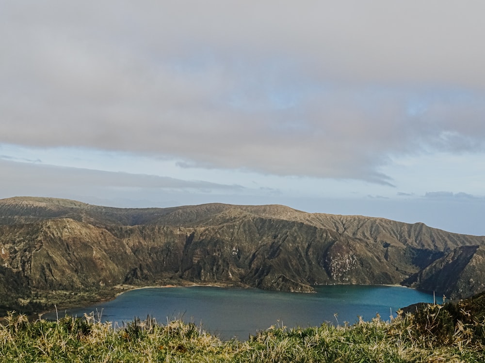 a view of a lake and mountains from the top of a hill