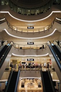 an escalator in a shopping mall with people walking around