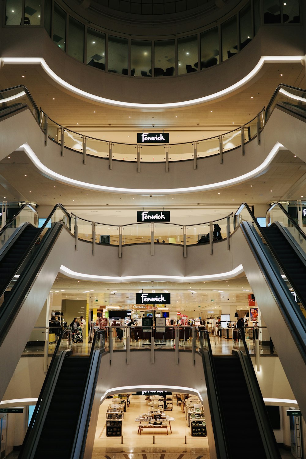 an escalator in a shopping mall with people walking around