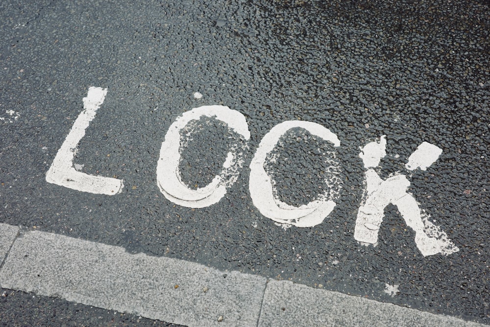 a close up of a street with the word lock painted on it