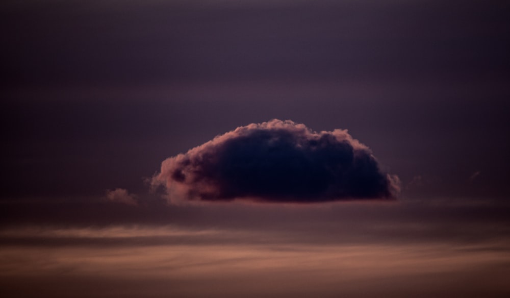 a large cloud in the sky with a dark background