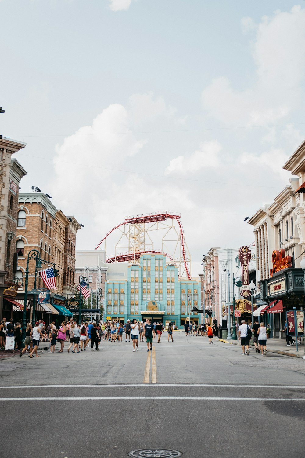 a city street with a roller coaster in the background