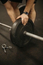 a man lifting a barbell with a pair of scissors