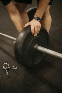 a man lifting a barbell with a pair of scissors