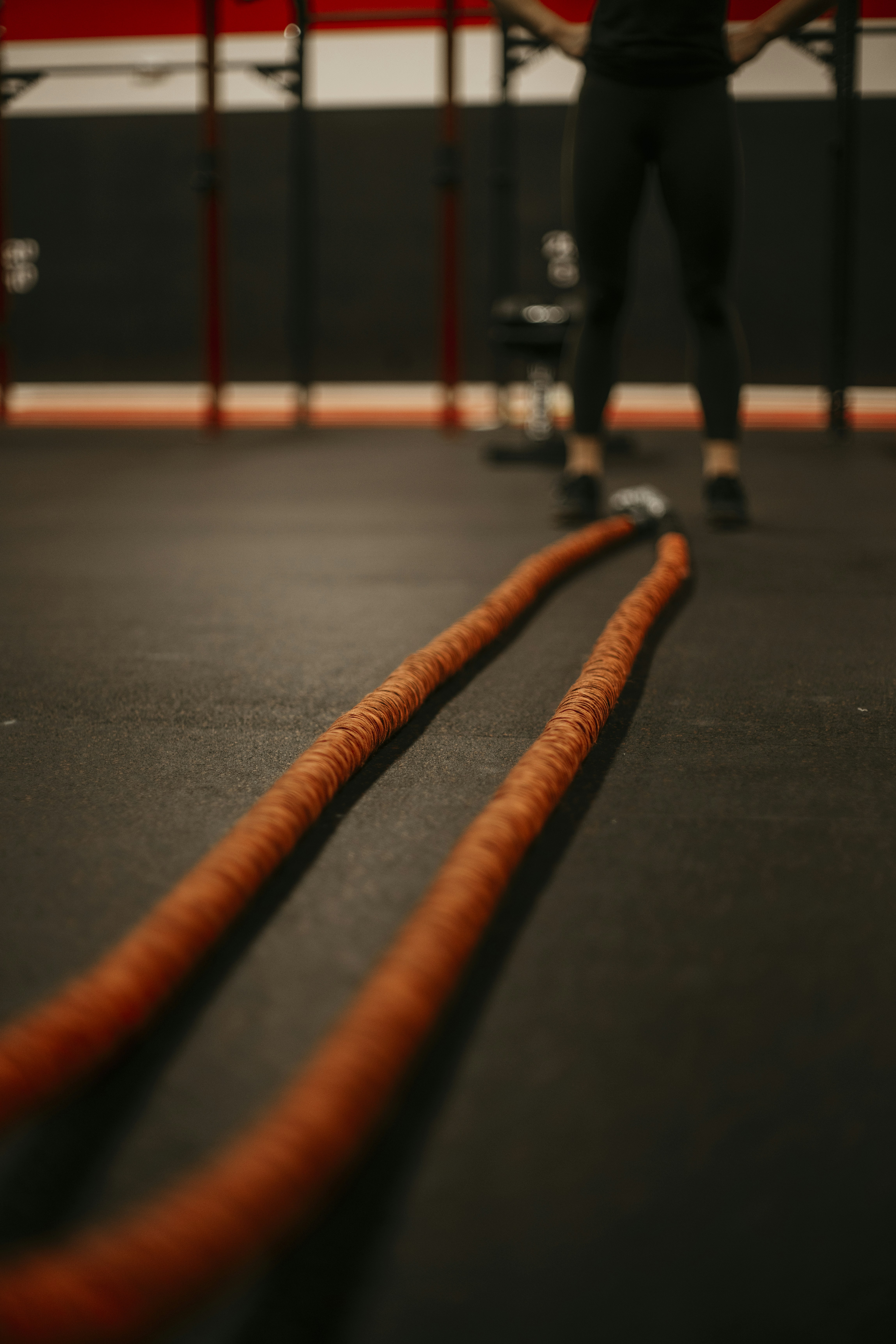 a man standing in a gym holding a rope