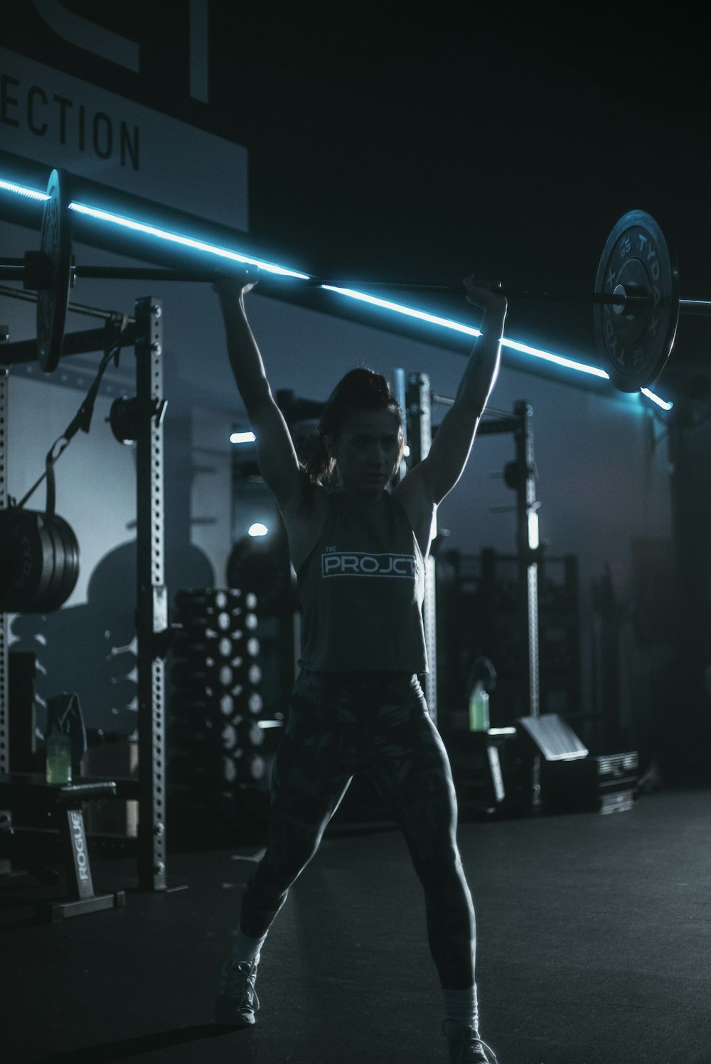 a woman lifting a barbell in a gym