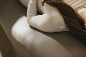 a woman with long hair laying on a couch